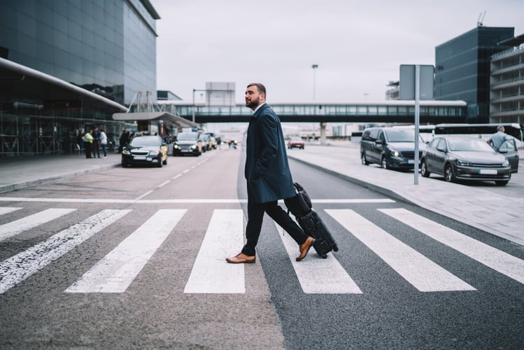 Ein Mann mit Koffer läuft über den Zebrastreifen. Er symbolisiert die Employee Journey. 