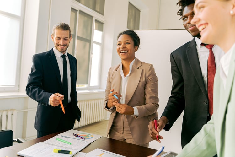 Eine Mitarbeiterin lacht mit ihren beiden Kollegen, denn sie hat eine gute Candidate Experience bei ihrem neuen Arbeitgeber.