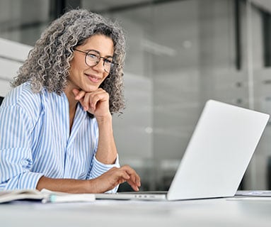 Eine Frau sitzt vor ihrem Laptop und nimmt an dem Online Seminar, Webinar von contec zum Thema 