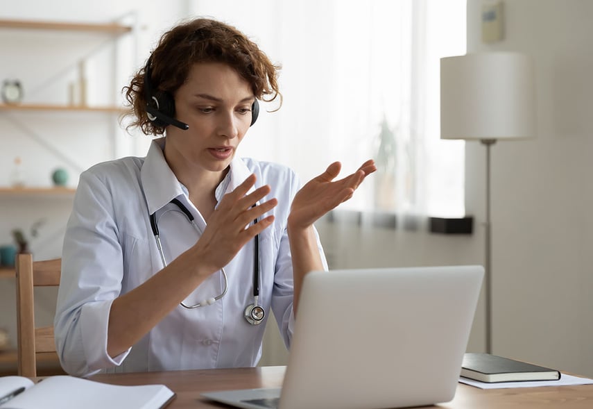 Eine Ärztin sitzt mit einem Headset vor einem Computerbildschirm - ontec GmbH Unternehmensberatung und Personalberatung der Gesundheitswirtschaft und Sozialwirtschaft