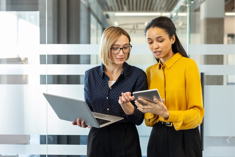 Zwei Frauen schauen auf ein Tablet und bestimmen den digitalen Reifegrad einer Organisation der Sozialwirtschaft