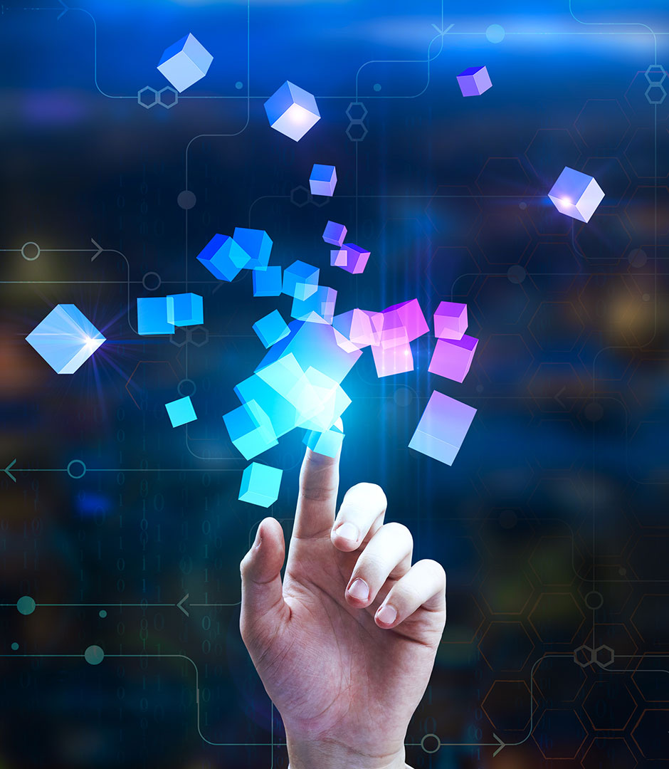 Eine Hand zeigt auf viele bunte 3-D-Würfel, die die KI-Transformation symbolisch darstellen sollen