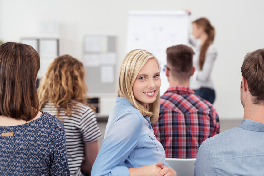 junge frau sitzt in deiner konferenz und schaut zurück