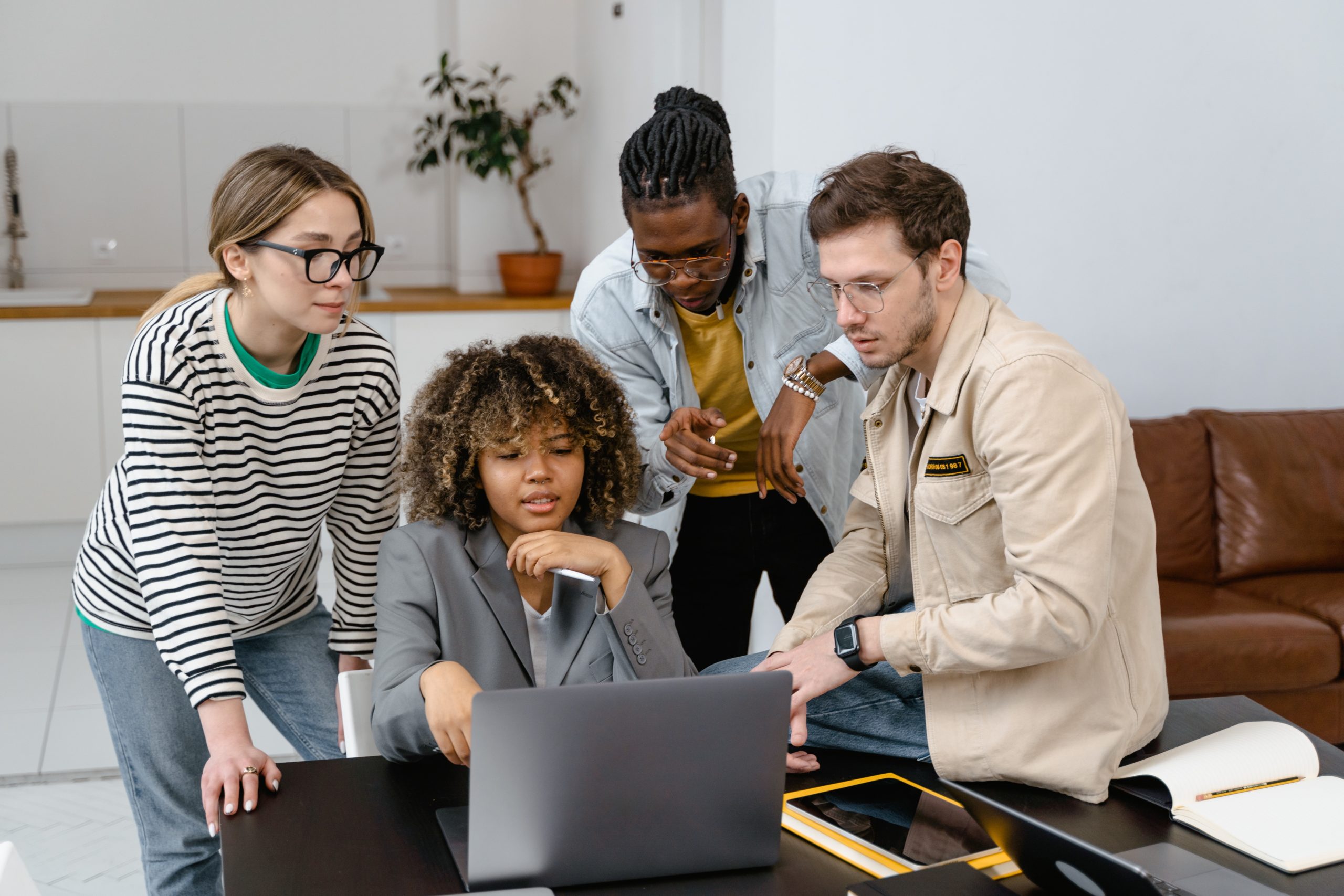 Employer Branding Führungskräfte - Mitarbeitende zusammen vor einem Laptop