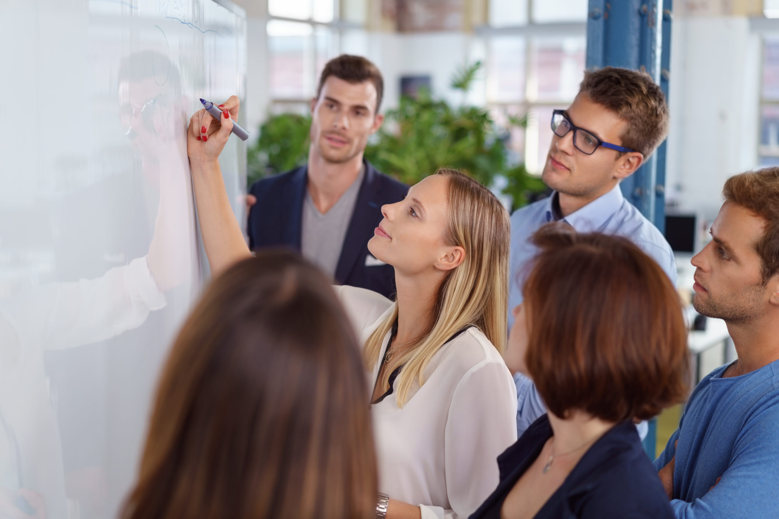 Strategie entwickeln - frau schreibt an ein board im büro